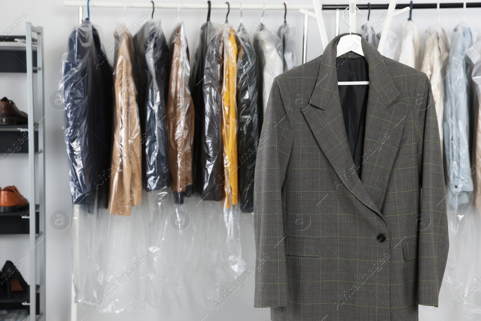 Photo of Dark business suit at dry-cleaner's. Space for text