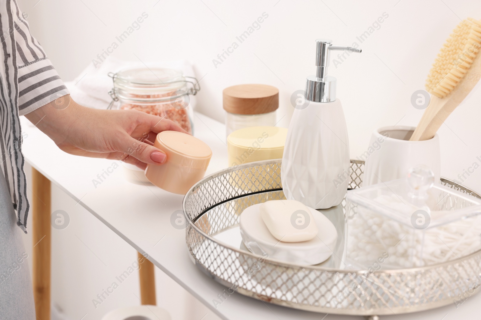 Photo of Bath accessories. Woman with jar of cosmetic product indoors, closeup