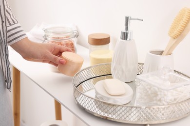 Bath accessories. Woman with jar of cosmetic product indoors, closeup