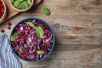 Photo of Fresh red cabbage salad served on wooden table, flat lay. Space for text