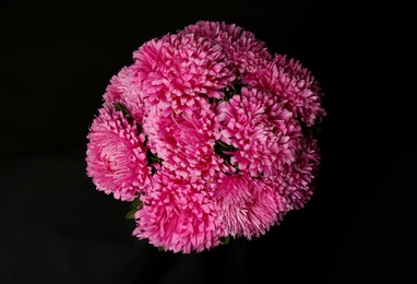 Bouquet of beautiful pink asters on black background, top view. Autumn flowers