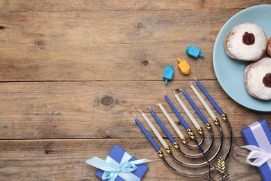 Photo of Flat lay composition with Hanukkah menorah and gift boxes on wooden table. Space for text