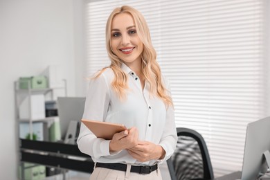 Portrait of happy secretary with tablet in office