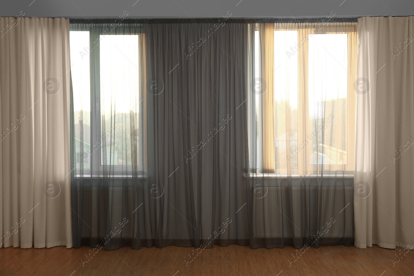Photo of Windows with beautiful curtains in empty room