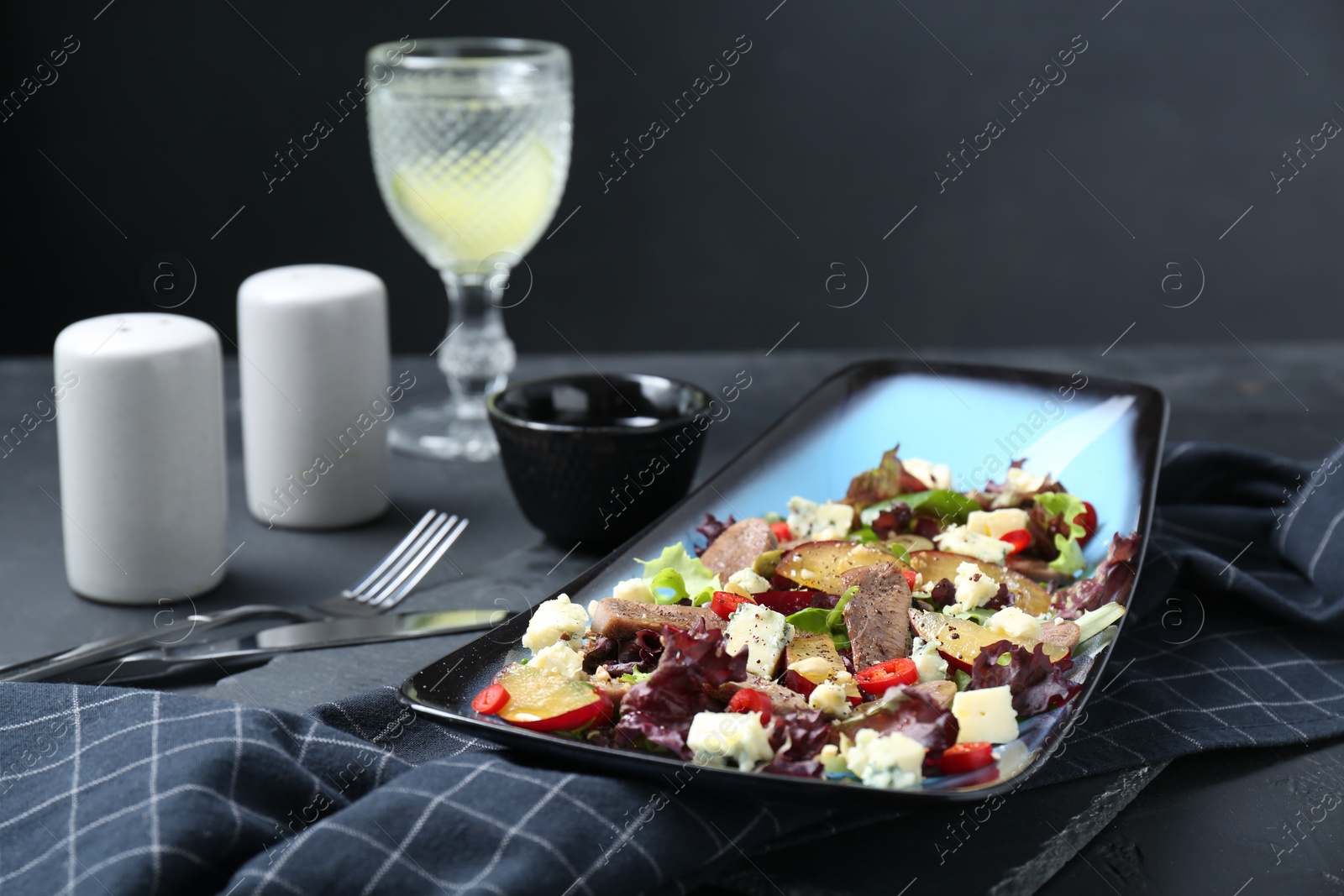 Photo of Delicious salad with beef tongue and cheese served on black table. Space for text