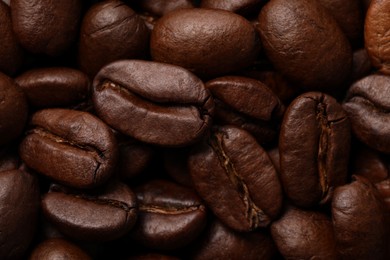 Photo of Aromatic roasted coffee beans as background, closeup