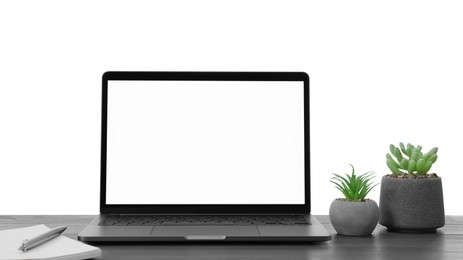 Photo of Laptop, potted plants and notebook on table against white background. Stylish workplace