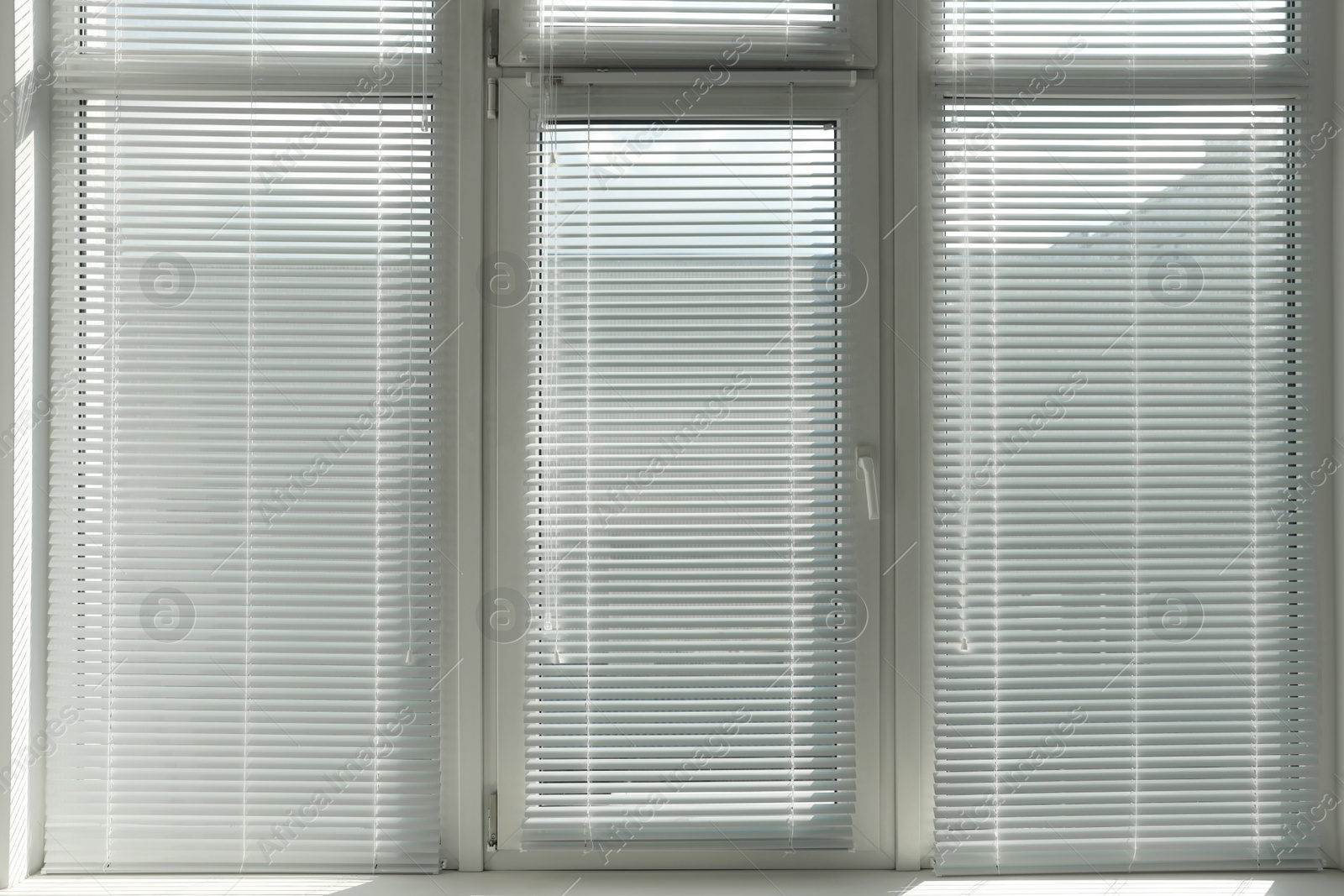 Photo of Stylish window with horizontal blinds in room