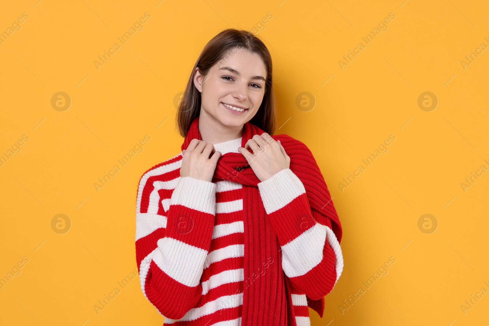 Photo of Beautiful woman in warm scarf on yellow background