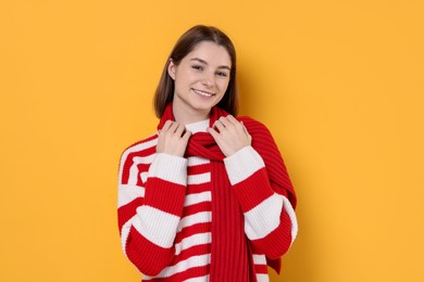 Photo of Beautiful woman in warm scarf on yellow background