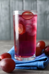 Photo of Delicious grape soda water on grey table. Refreshing drink