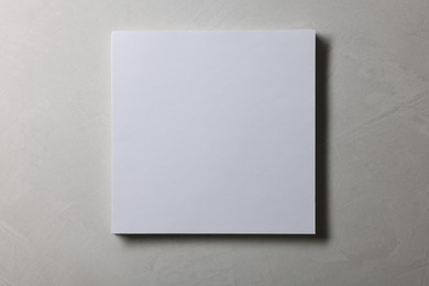 Blank paper sheets on grey textured background, top view. Mockup for design