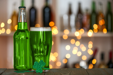 Photo of Green beer and clover on wooden counter, space for text. St.Patrick's Day celebration