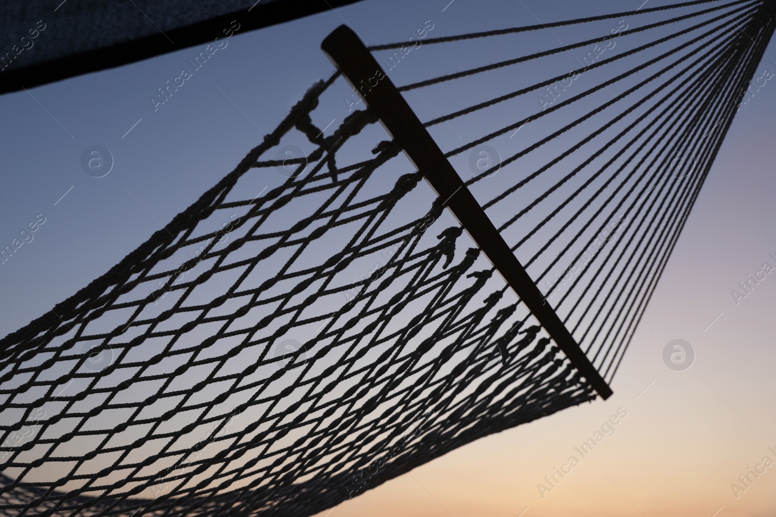 Photo of Empty hammock on beach at sunset. Time to relax