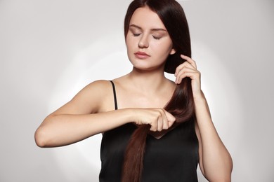 Photo of Beautiful young woman with healthy strong hair posing in studio