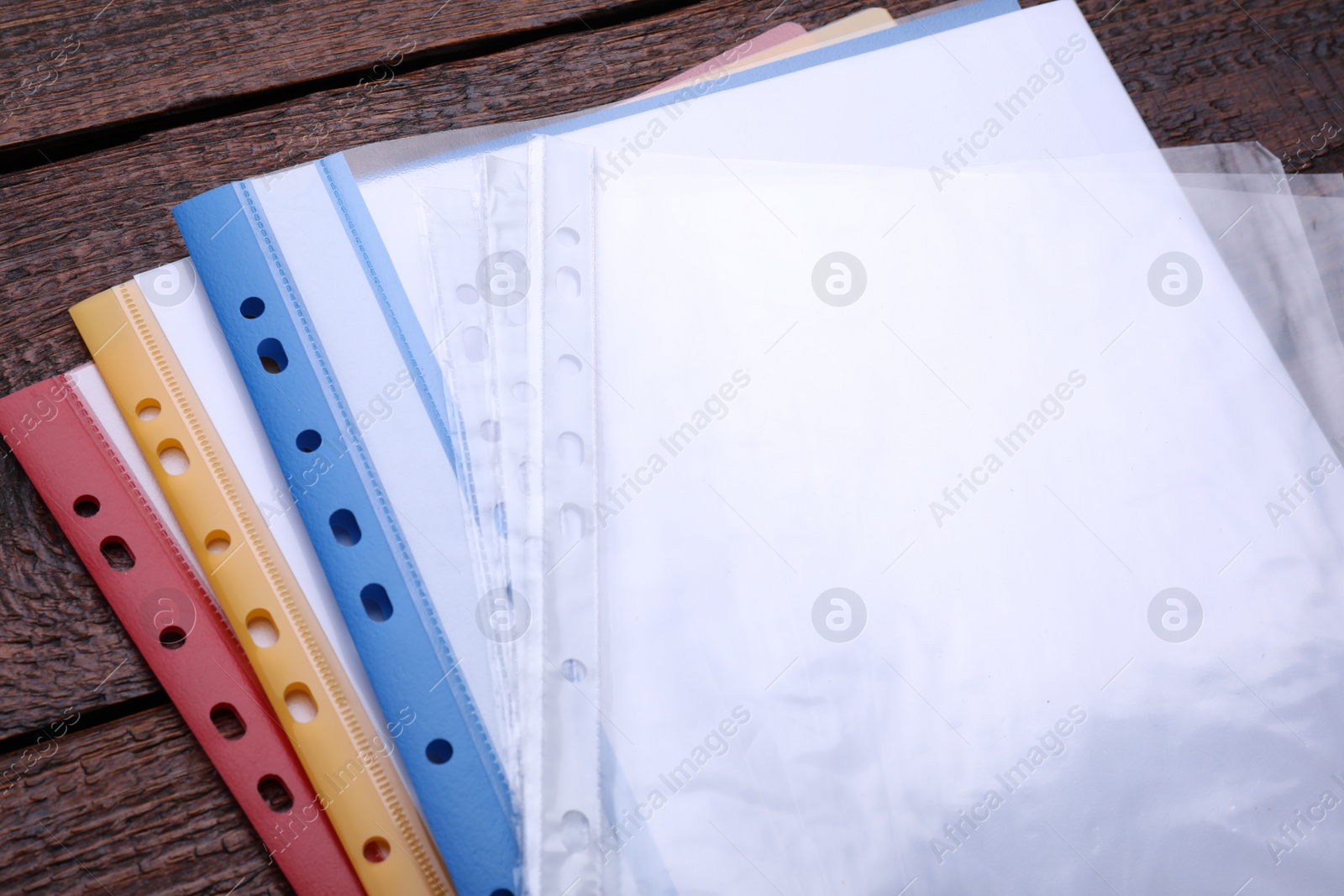 Photo of File folders with punched pockets on wooden table