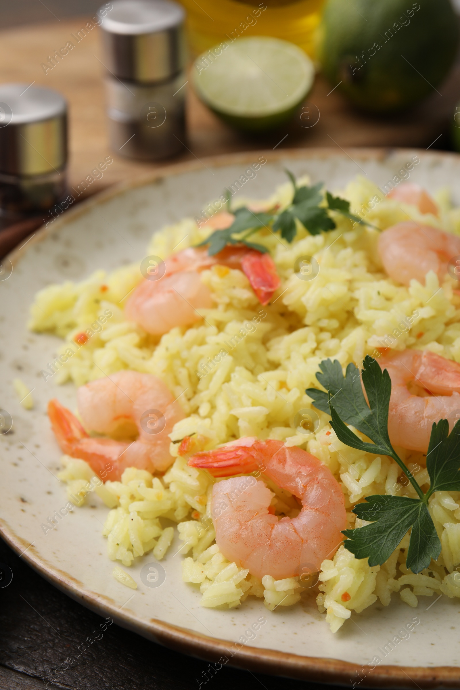 Photo of Delicious risotto with shrimps and parsley on wooden table, closeup