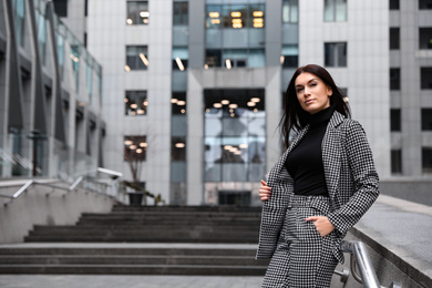 Portrait of beautiful woman in stylish suit on city street. Space for text