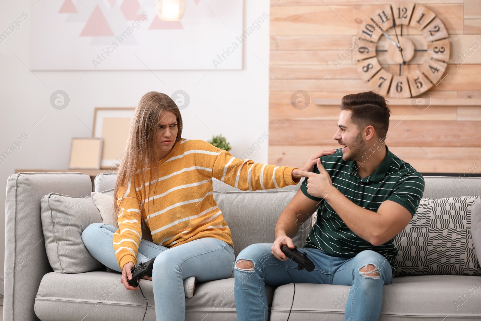 Photo of Emotional young couple playing video games at home