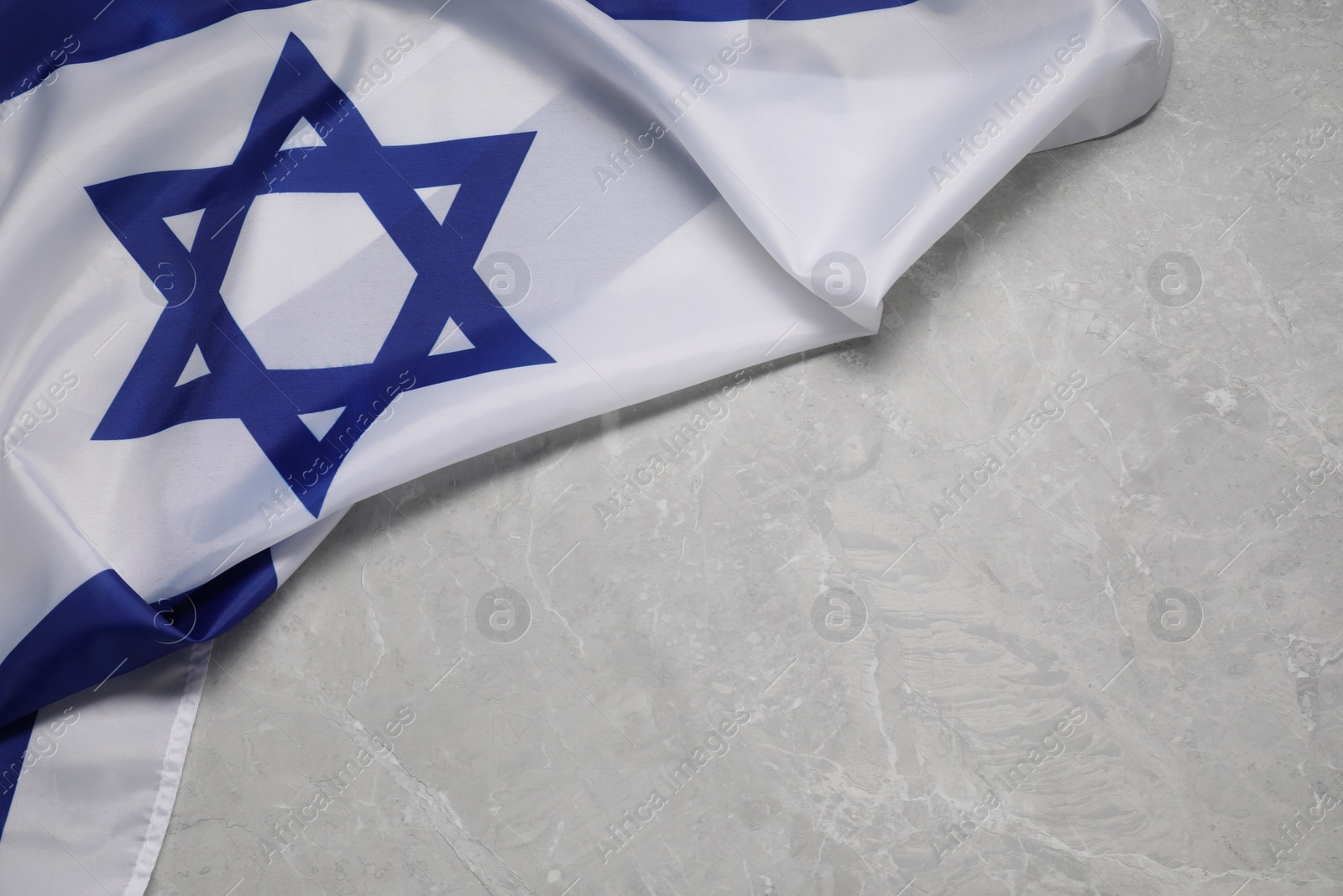 Photo of Flag of Israel on grey marble background, top view and space for text. National symbol