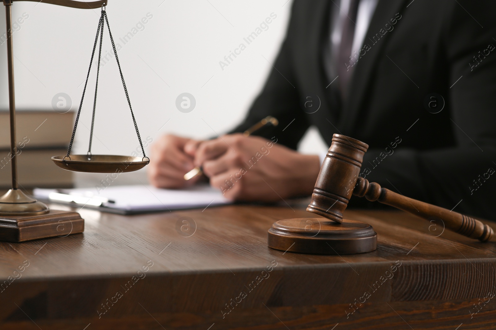 Photo of Law and justice. Closeup of judge working at wooden table, focus on gavel