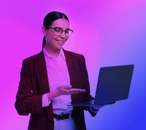 Image of Beautiful woman with laptop in neon lights