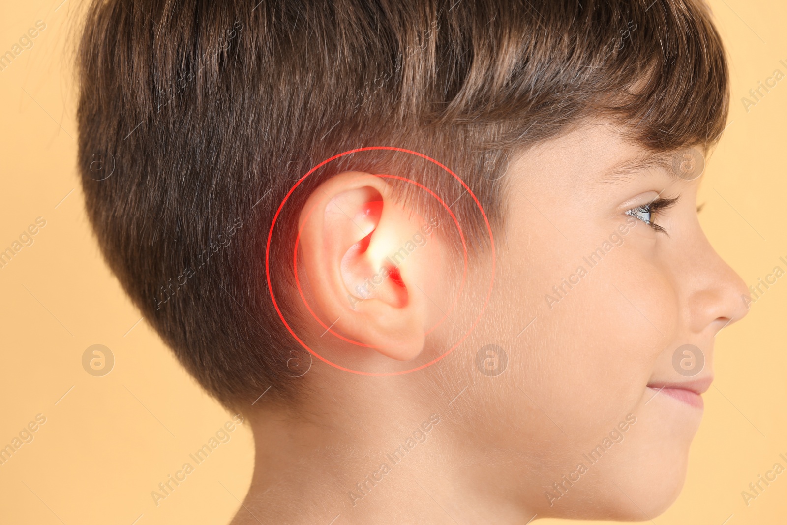 Image of Little boy on color background, closeup. Hearing problem