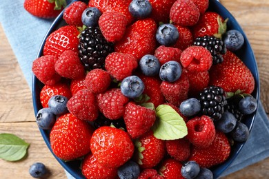 Different fresh ripe berries on wooden table, top view