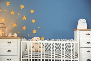 Stylish baby room interior with comfortable crib