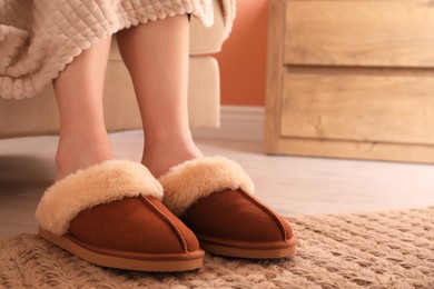 Woman in warm soft slippers at home, closeup