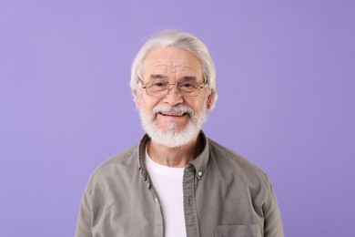 Photo of Portrait of stylish grandpa with glasses on purple background