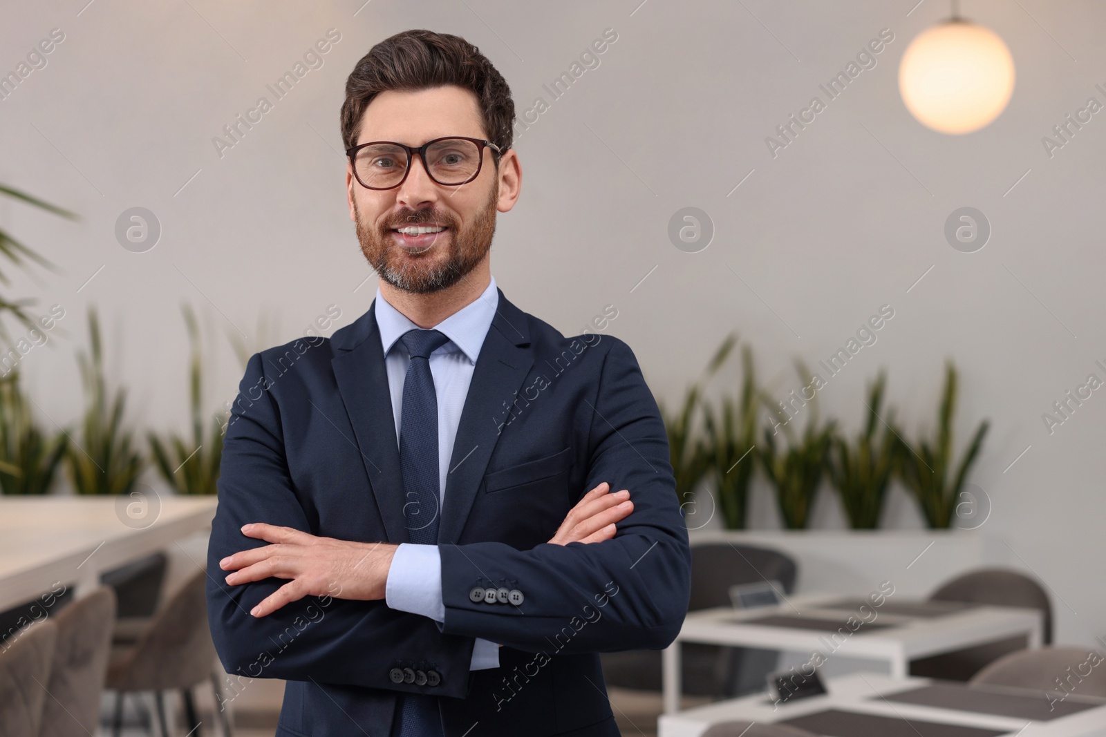 Photo of Happy real estate agent indoors. Space for text