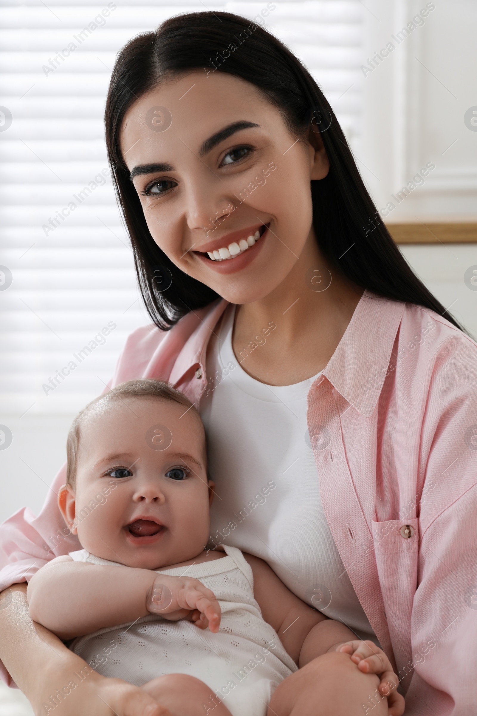 Photo of Young mother with her little baby at home