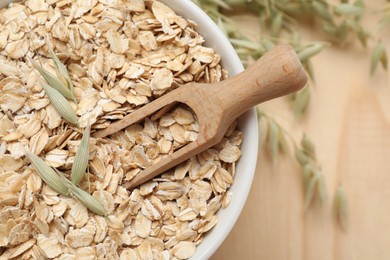 Photo of Bowl and scoop of oatmeal with florets on table, top view. Space for text