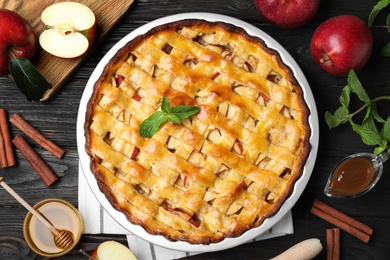 Photo of Flat lay composition with fresh traditional apple pie on black wooden table