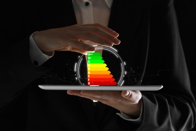 Image of Energy efficiency rating coming out of tablet. Man using device, closeup