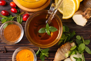 Photo of Flat lay composition of tea with honey and ingredients on wooden table