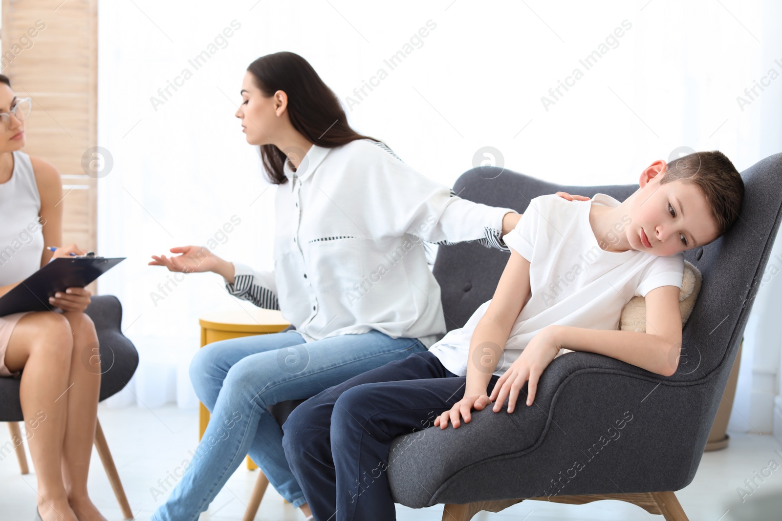 Photo of Young woman and her son having appointment with child psychologist in office