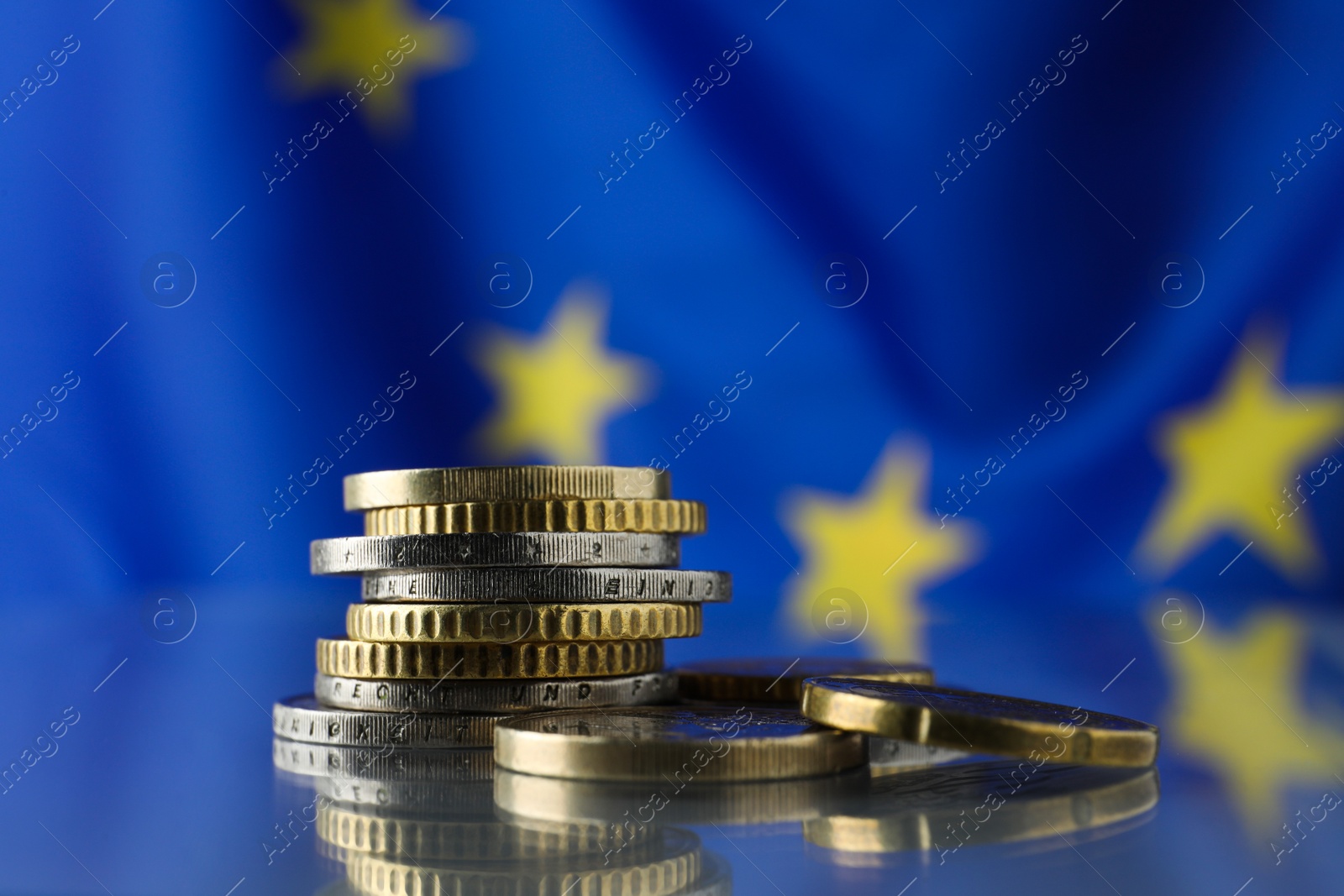 Photo of Coins on table against European Union flag, closeup. Space for text