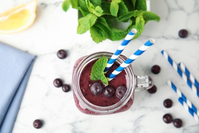 Photo of Mason jar with delicious acai smoothie on table, top view