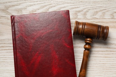 Photo of Law. Book and gavel on wooden table, flat lay