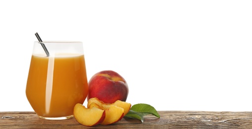 Photo of Freshly made tasty peach juice on wooden table against white background
