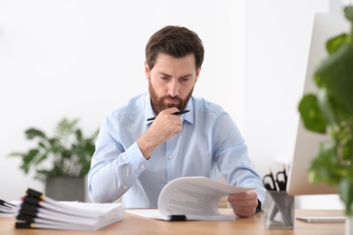 Businessman working with documents at wooden table in office