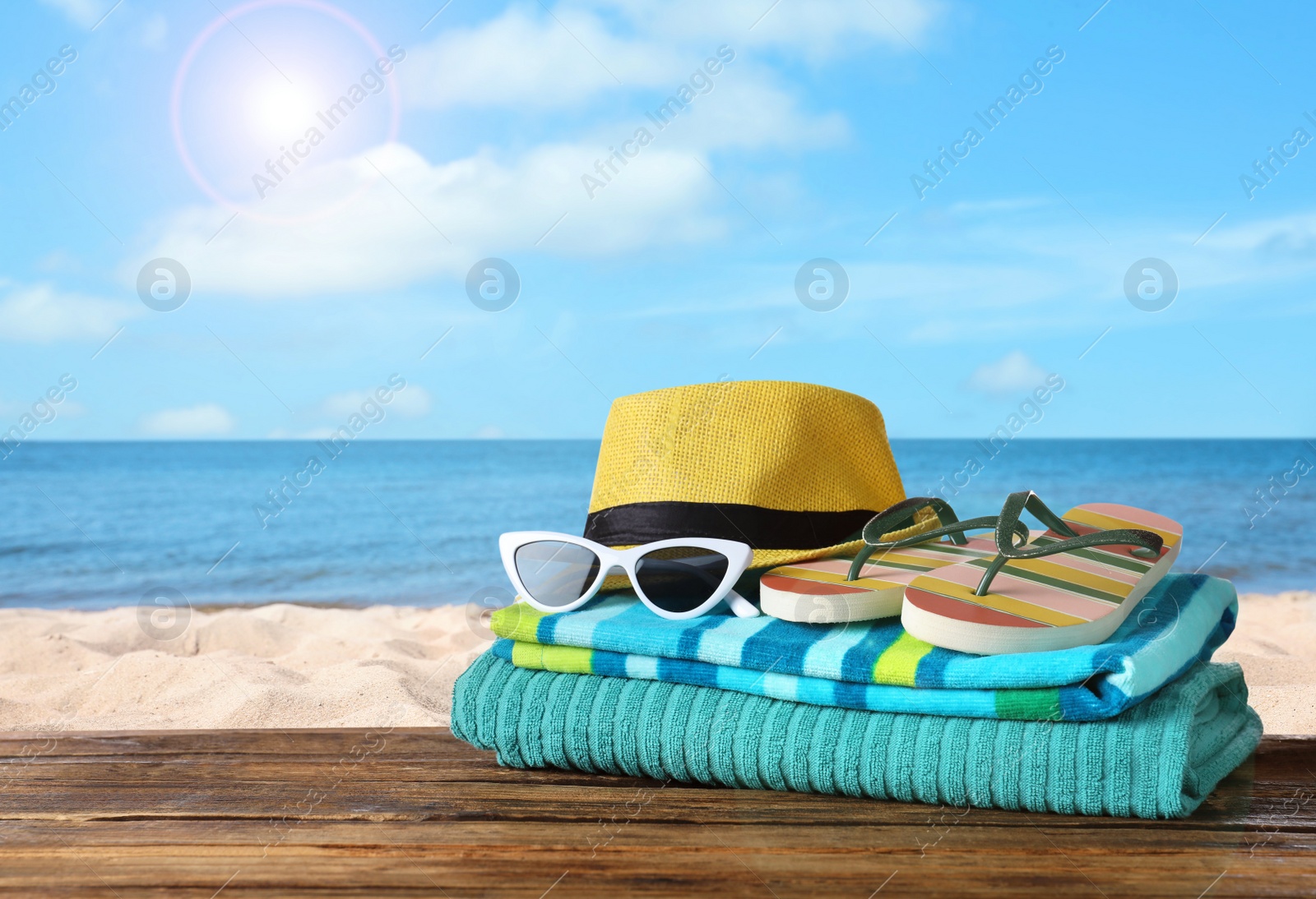 Image of Beach objects on wooden table near sea, space for text. Summer vacation 