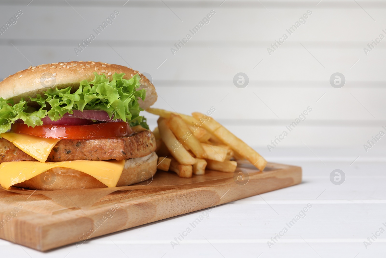 Photo of Delicious tofu burger served with french fries on white table. Space for text