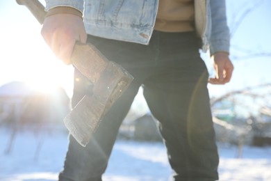 Photo of Man with axe outdoors on sunny winter day, closeup