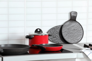 Different clean cookware on stove in kitchen. Space for text