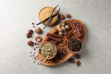 Photo of Different spices and nuts on light gray table, flat lay