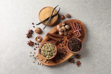 Different spices and nuts on light gray table, flat lay