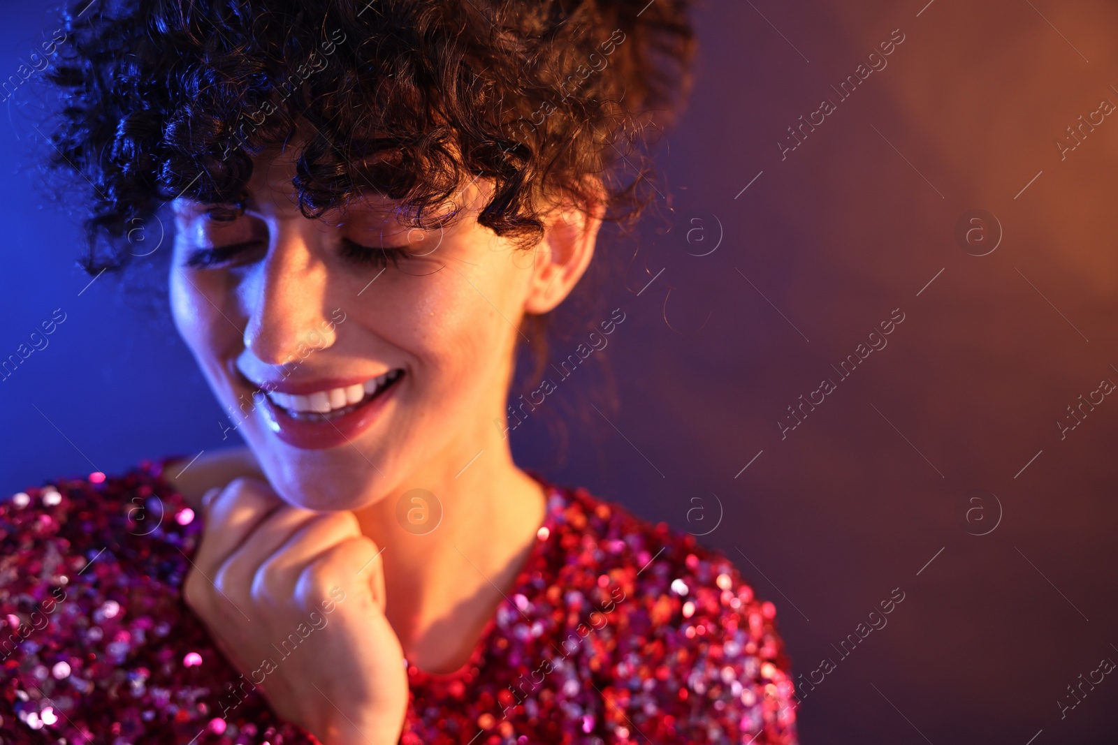 Photo of Beautiful young woman posing on color background in neon lights